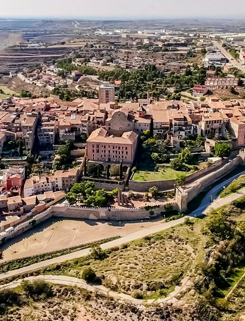 Vista aèria del nucli antic de Cervera i del perímetre de muralles, amb els camps de la Segarra al fons