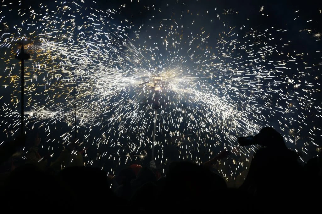 Espurnes del correfoc de l’Aquelarre de Cervera sobre les siluetes del públic.