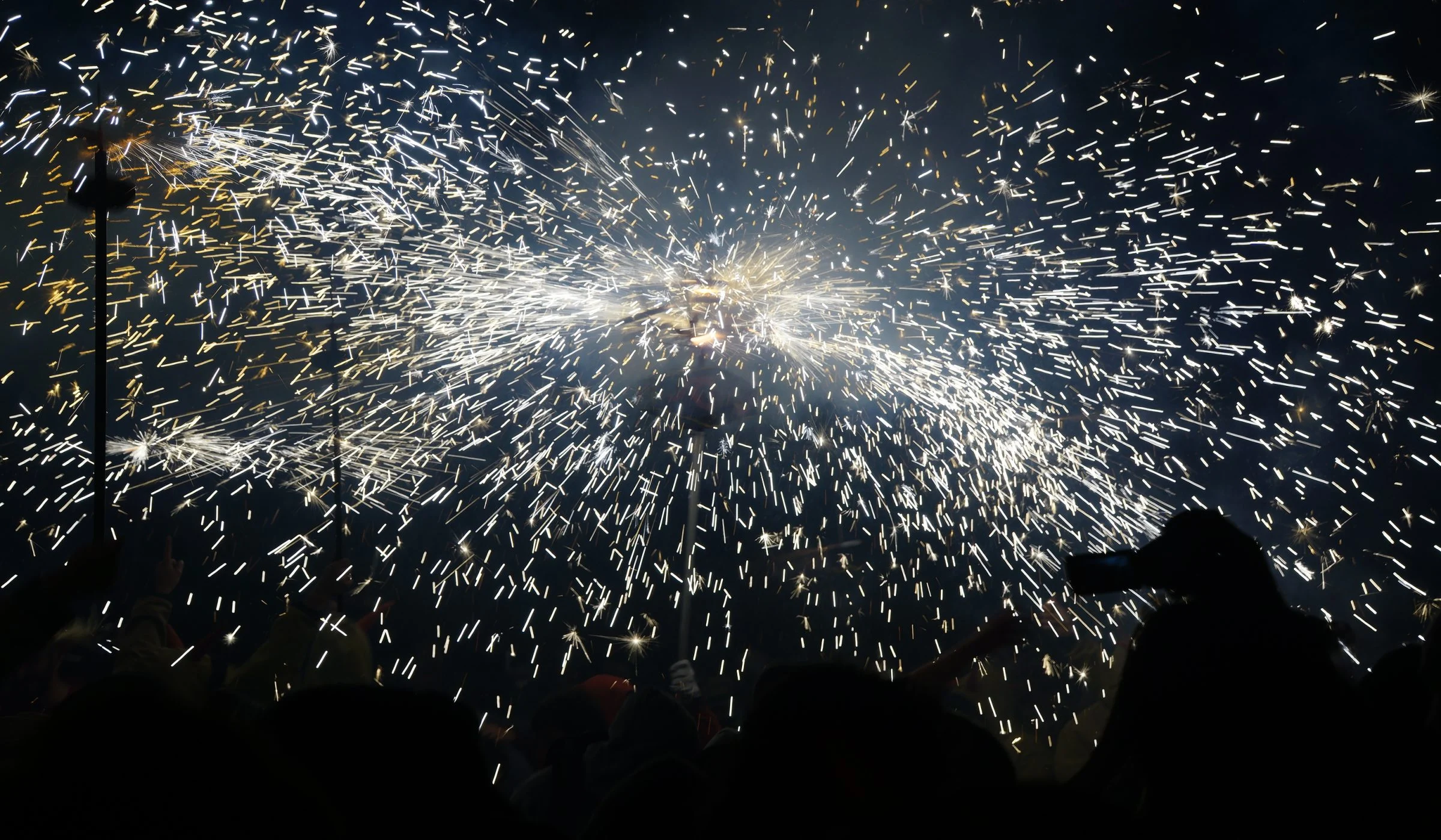 Espurnes del correfoc de l’Aquelarre de Cervera sobre les siluetes del públic.