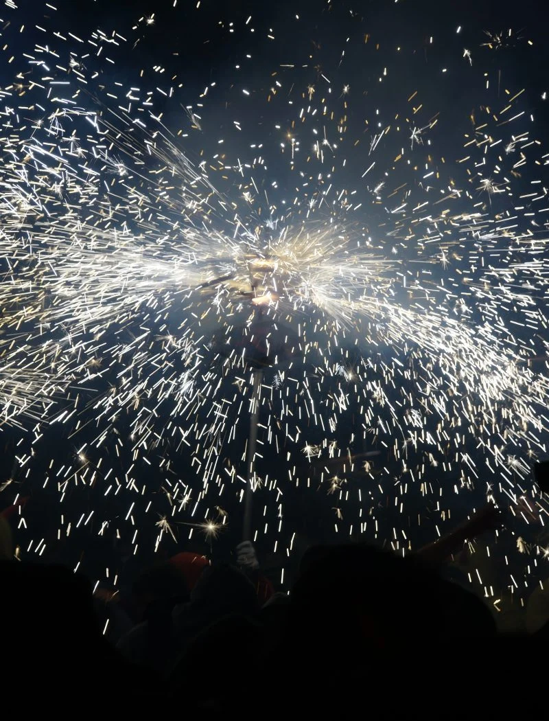 Espurnes del correfoc de l’Aquelarre de Cervera sobre les siluetes del públic.