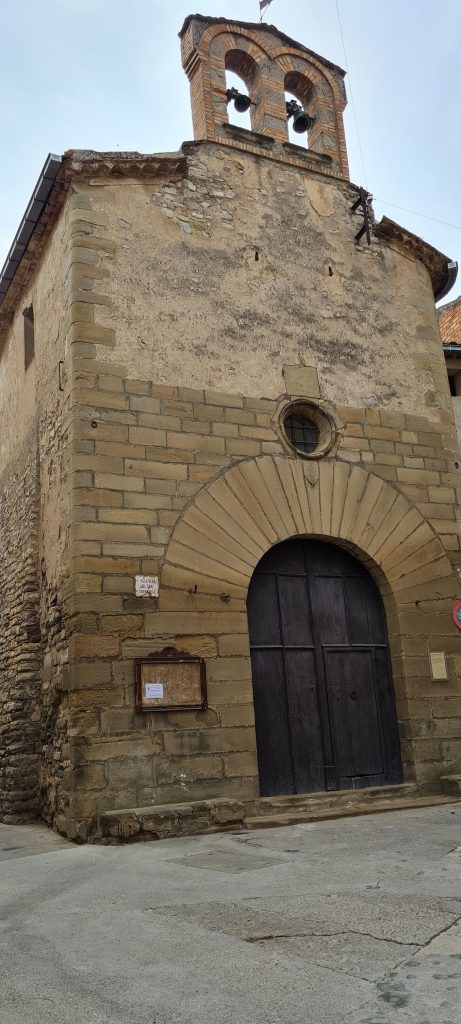 Portal de pedra i campanar de la capella de Sant Cristòfol de Cervera.