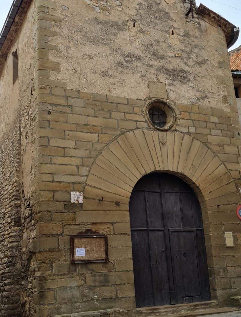Portal de pedra i campanar de la capella de Sant Cristòfol de Cervera.